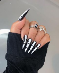 closeup de uñas con nail art de huesos emulando un esqueleto