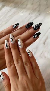 closeup de uñas con nail art de lunas y estrellas en blanco y negro