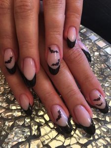 closeup de uñas con nail art de murcielagos