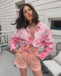 plano americano chica vistiendo una blusa tie dye y pantalones cortos en color rosa